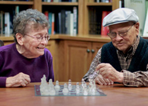 elderly couple playing chess